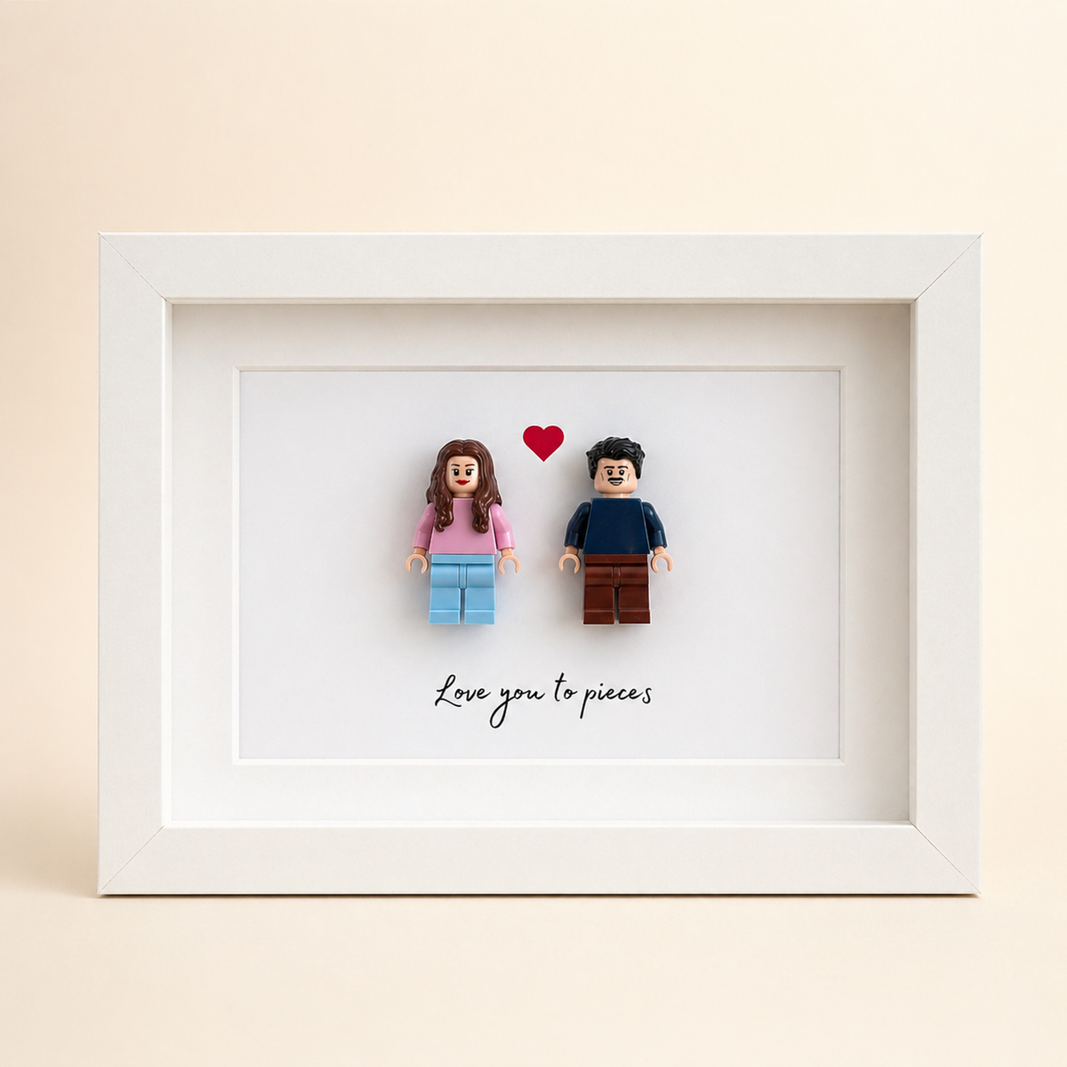 White personalized frame with two custom minifigures, a red heart and Love you to pieces wording