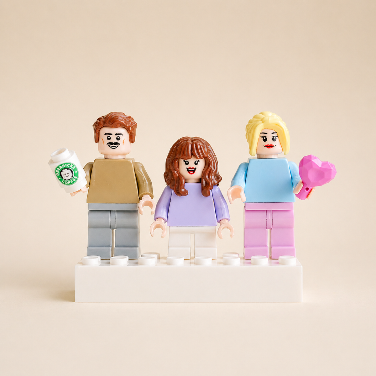 Three personalized family minifigures with a coffee cup and pink heart on a white display base